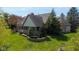 Lush backyard featuring mature trees, shrubs, and beautiful retaining wall at 7371 Windridge Way, Brownsburg, IN 46112