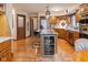 Open kitchen features granite island, stainless appliances, wine fridge, and hardwood floors at 7371 Windridge Way, Brownsburg, IN 46112