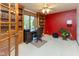 Home office featuring built-in bookshelves, a desk, and a bright red accent wall at 7371 Windridge Way, Brownsburg, IN 46112