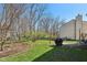 Landscaped backyard with mature trees, patio, and fire pit, ideal for relaxation at 7418 Bluebird Ct, Indianapolis, IN 46254