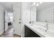 Bright bathroom featuring a double vanity with updated fixtures, and a hallway to another room at 7418 Bluebird Ct, Indianapolis, IN 46254