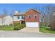 Classic two-story home featuring a brick facade, attached garage, and green lawn at 7418 Bluebird Ct, Indianapolis, IN 46254