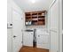 Functional laundry room includes a washer, dryer, storage shelves and a door to the outside at 7418 Bluebird Ct, Indianapolis, IN 46254