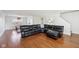 Spacious living room with hardwood floors and a large black leather sectional sofa at 7418 Bluebird Ct, Indianapolis, IN 46254