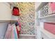 Walk-in closet featuring storage shelves and drawers, complemented by charming floral wallpaper at 7418 Bluebird Ct, Indianapolis, IN 46254