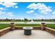 Backyard with patio featuring a fire pit and a serene water view beyond the lush green lawn at 749 Meadowbrook Ln, Franklin, IN 46131