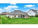 Expansive backyard featuring a covered patio with a built-in outdoor kitchen and a lush green lawn at 749 Meadowbrook Ln, Franklin, IN 46131