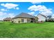 Lush backyard view with a well-kept lawn, patio area, and distant residential architecture at 749 Meadowbrook Ln, Franklin, IN 46131