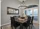 Stylish dining room featuring a dark wood table, modern chandelier, and plantation shutters at 749 Meadowbrook Ln, Franklin, IN 46131