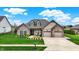 Charming home featuring a well-manicured lawn, stone accents, and a two-car garage at 749 Meadowbrook Ln, Franklin, IN 46131