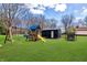 Lush backyard featuring a playground set with swings and a slide, a shed, and a trampoline, perfect for outdoor fun at 7859 Jennifer Ln, Brownsburg, IN 46112