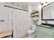 Charming bathroom with a mint green vanity, black countertop, patterned shower curtain, and modern fixtures at 7859 Jennifer Ln, Brownsburg, IN 46112