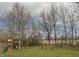 Spacious backyard featuring a playground, swing set, lush green grass, and mature trees at 796 Booneway Ln, Bargersville, IN 46106