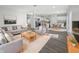 Open-concept living space with modern gray sofas, an adjacent kitchen, and hardwood-style flooring for spacious living at 8251 Garden Ridge Rd, Indianapolis, IN 46237