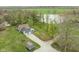 Aerial view of a blue home near a pond, featuring a long driveway, outbuildings, and a well-maintained lawn at 8394 S 600 W, Pendleton, IN 46064