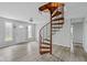 Bright living room with spiral staircase, light gray walls, and sleek flooring at 8394 S 600 W, Pendleton, IN 46064