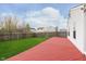 Well-maintained backyard featuring a red wooden deck, a privacy fence, and a green lawn at 8529 Sansa St, Camby, IN 46113