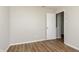 Cozy bedroom featuring wood-look floors, neutral paint, and a doorway to another room at 8529 Sansa St, Camby, IN 46113