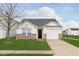 Well-maintained single-story home featuring a one-car garage, brick accents, and a neatly manicured front lawn at 8529 Sansa St, Camby, IN 46113