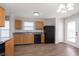 Spacious kitchen with wood cabinets, stainless steel sink, black appliances, and wood-look flooring at 8529 Sansa St, Camby, IN 46113