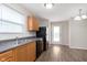 Bright kitchen with stainless steel sink, black appliances, and wood-look flooring, perfect for cooking and entertaining at 8529 Sansa St, Camby, IN 46113