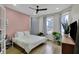 Bedroom featuring large windows, a ceiling fan, and a pink accent wall at 922 Cottage Ave, Indianapolis, IN 46203