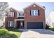 Charming two-story brick home featuring a well-maintained lawn, black shutters, and attached two-car garage at 10105 Yosemite Ln, Indianapolis, IN 46234