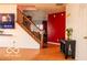 Bright entry foyer featuring hardwood floors, staircase, and decorative red wall at 10105 Yosemite Ln, Indianapolis, IN 46234
