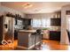 Modern kitchen with stainless steel appliances, island with seating, and dark cabinets at 10105 Yosemite Ln, Indianapolis, IN 46234