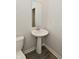 Clean bathroom with pedestal sink, white toilet, and modern finishes at 10319 Pronghorn Ln, Indianapolis, IN 46239