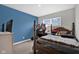 Cozy bedroom featuring a comfortable bed, blue accent wall and ample natural light at 10319 Pronghorn Ln, Indianapolis, IN 46239