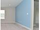 Bright bedroom with neutral tones, blue accent wall, a window with blinds, and carpeted floors at 10319 Pronghorn Ln, Indianapolis, IN 46239