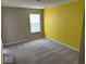Bedroom with neutral carpet and a yellow accent wall, offering ample natural light at 10319 Pronghorn Ln, Indianapolis, IN 46239