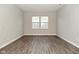 Neutral bedroom featuring hardwood floors, modern trim, and a large window for plenty of natural light at 10319 Pronghorn Ln, Indianapolis, IN 46239