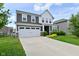 Two story home with a two car garage, gray siding, and well-maintained landscaping at 10319 Pronghorn Ln, Indianapolis, IN 46239