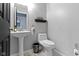 Clean powder room showcasing pedestal sink, modern toilet, and stylish accessories at 10955 Balfour Dr, Noblesville, IN 46060
