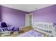 This charming bedroom features an accent wall, a cozy chair and a baby crib at 10955 Balfour Dr, Noblesville, IN 46060