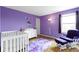 This charming bedroom features an accent wall, a cozy chair and a baby crib at 10955 Balfour Dr, Noblesville, IN 46060