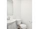 A half bathroom features a pedestal sink, a framed mirror, and a low-flow toilet at 1117 Stubble Run, Danville, IN 46122