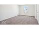 A bright bedroom features neutral carpet, a window, and white walls at 1117 Stubble Run, Danville, IN 46122