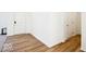Hallway with wood floors and white walls showing the transition from the front door to a carpeted room at 1117 Stubble Run, Danville, IN 46122