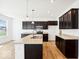 A spacious kitchen with stainless steel appliances, dark wood cabinets, and a center island at 1117 Stubble Run, Danville, IN 46122