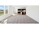 Bright and airy living room with plush carpeting leading to a modern kitchen with dark cabinets and stainless appliances at 1117 Stubble Run, Danville, IN 46122