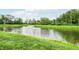 Beautiful pond featuring a fountain, grassy shoreline, and mature trees at 1117 Stubble Run, Danville, IN 46122