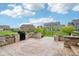 Spacious backyard patio with stone seating area, landscaping, and black grill at 13494 Moorcroft Dr, Fishers, IN 46037