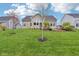 View of the home's backyard, with a lush lawn, patio, and mature trees at 13494 Moorcroft Dr, Fishers, IN 46037