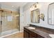 Bathroom featuring granite counters, walk-in shower with glass door and dual mirrors at 13494 Moorcroft Dr, Fishers, IN 46037