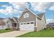 Side view of a well-maintained two-car garage with stone accents on a home with green grass at 13494 Moorcroft Dr, Fishers, IN 46037