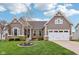 Charming home featuring stone accents, a two-car garage, and a well-manicured lawn at 13494 Moorcroft Dr, Fishers, IN 46037