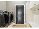 Laundry room featuring stainless steel washer and dryer, a built-in bench, and cabinet storage at 13494 Moorcroft Dr, Fishers, IN 46037